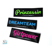 Drei Klettlogos mit Wunschtext: Prinzessin in Grün, Dreamteam in Blau, Girlpower in Pink