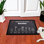 Kreidetafel-Fußmatte „Willkommen bei Familie Becker“ mit bunten Strichmännchen, Hund und Katze, vor einer weißen Haustür, daneben liegt ein Hund