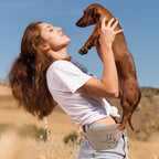 Imagebild Bauchtasche in Beige mit schwarzem Aufdruck. Frau mit Dackel auf dem Arm.