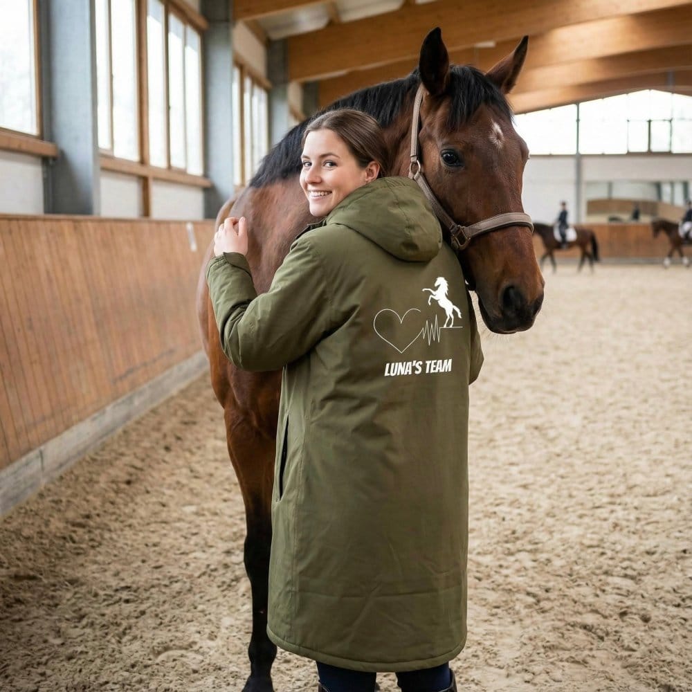 Pferdemensch mit Outdoor-Mantel beim Versorgen des Pferdes