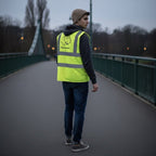 Ein Mann mit einer personalisierten Warnweste steht auf einer Brücke