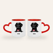 Weiße Tasse mit rotem Herzhenkel und gezeichnetem Stilporträt eines schwarzen Labradors mit dem Namen Bruno, Ansicht beider Seiten