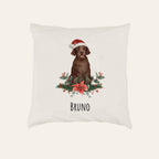 Flauschiges Kissen mit braunem Labrador mit Weihnachtsmütze zwischen Weihnachtsstern und Stechpalme, Name Bruno