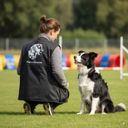Frau mit Hund beim Hundesport traegt personalisierte Hundesportweste mit Wunschname
