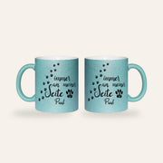 Hellblaue Glitzertasse mit dem Spruch Immer an meiner Seite, Pfotenspuren und dem Namen Paul, Ansicht beider Seiten