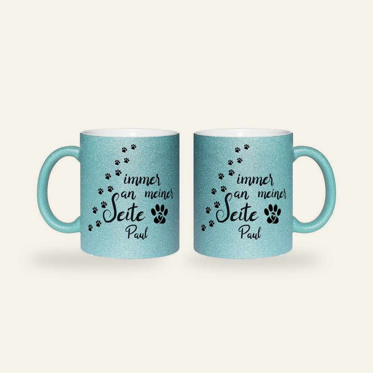 Hellblaue Glitzertasse mit dem Spruch Immer an meiner Seite, Pfotenspuren und dem Namen Paul, Ansicht beider Seiten